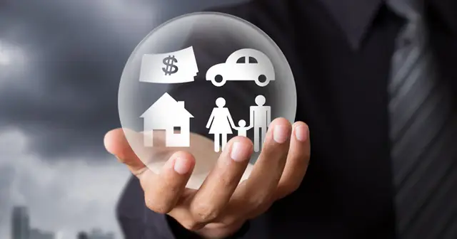 Mão segurando uma esfera com casa, carro e família